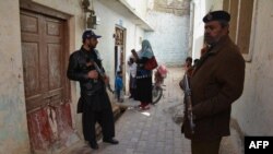 پاکستان کې د پوليو وایرس ضد واکسين ورکوونکې ډلې امنیتي ساتونکي د هغی پر پهره ولاړ دي ــ پخوانی انځور