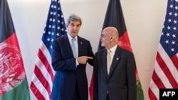 U.S. Secretary of State John Kerry (L) and Afghan President Ashraf Ghani pose for photographers during a Conference on Afghanistan in Brussels on October 4.