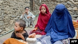 د ننګرهار د دره نور ولسوالۍ په زلزله کې یوه زیانمن شوې میرمن او ماشومان یې