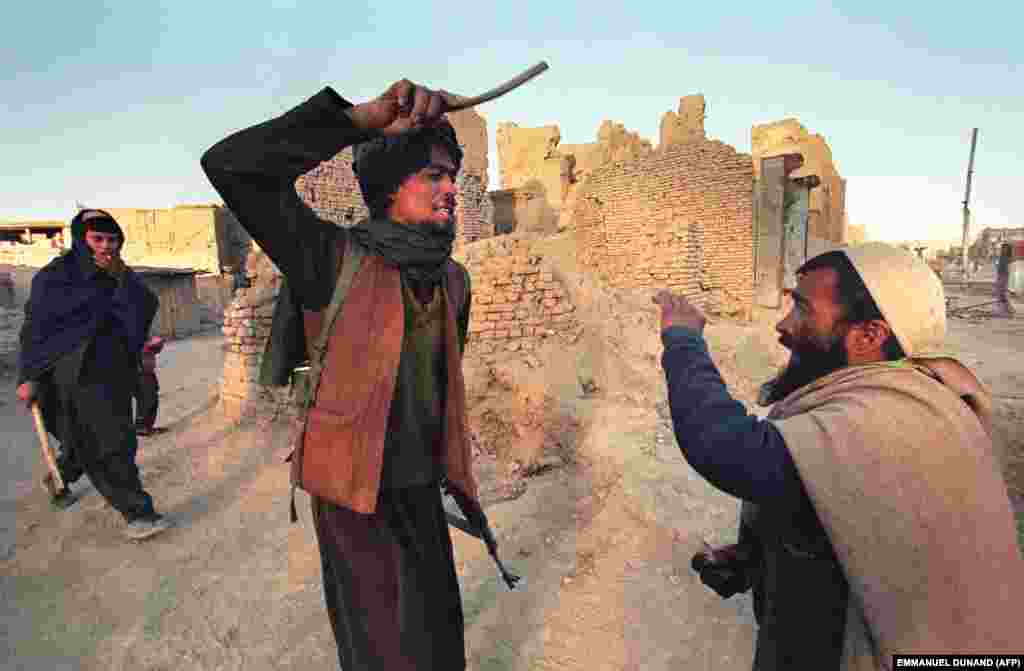 Un taliban lovește un bărbat prins cu jumătate de kilogram de opiu. Grupul sunnit a promis că va restabili ordinea și va eradica corupția în Afganistanul devastat de război.