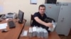 Vachagan Ghazarian empties his bag filled with cash after being arrested by the National Security Service in Yerevan on June 25.